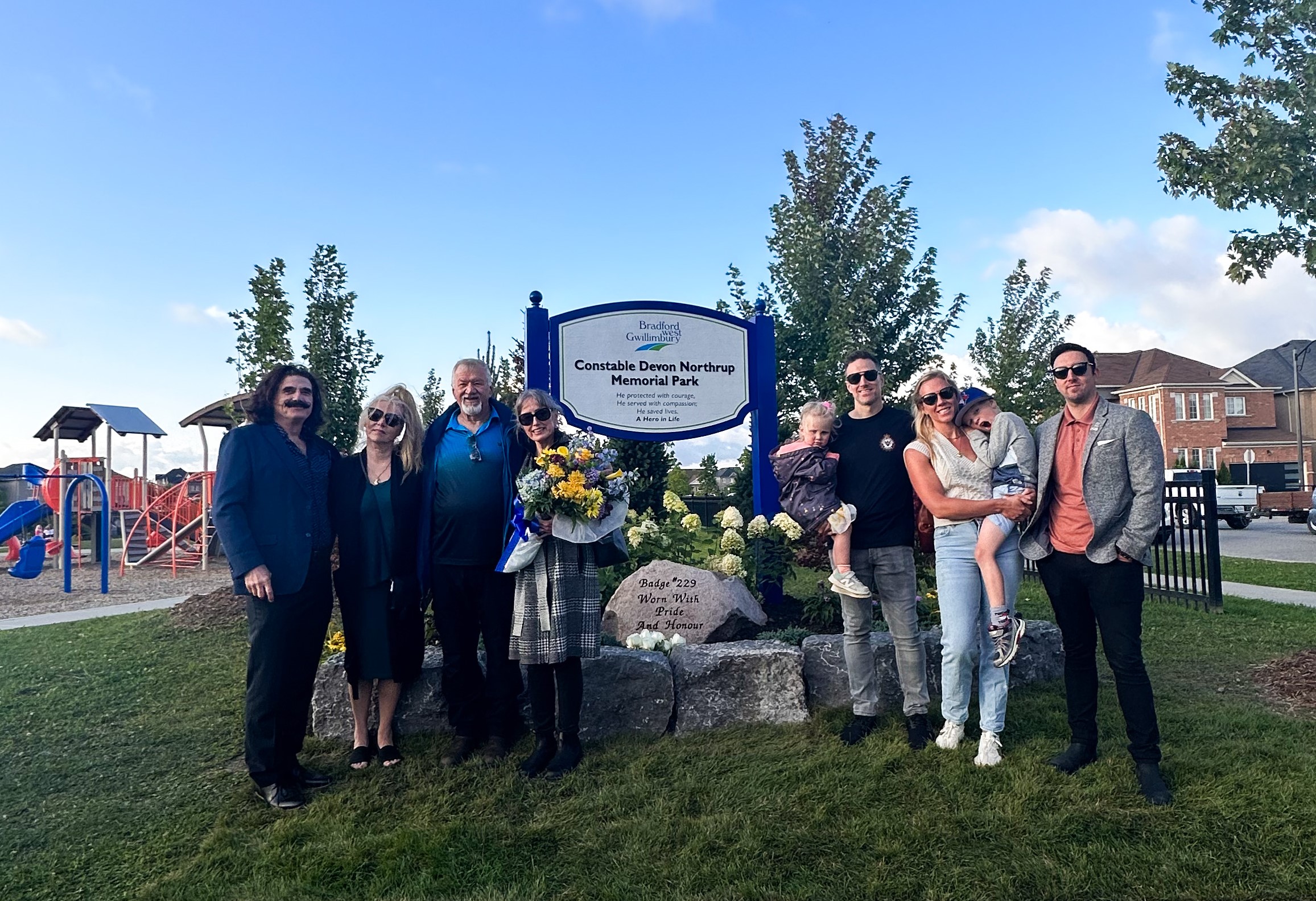 Cst. Northrup's family standing in front of the new park sign