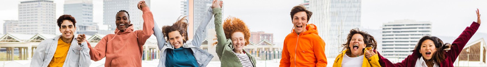 Image of teenagers holding hands and jumping up in the air